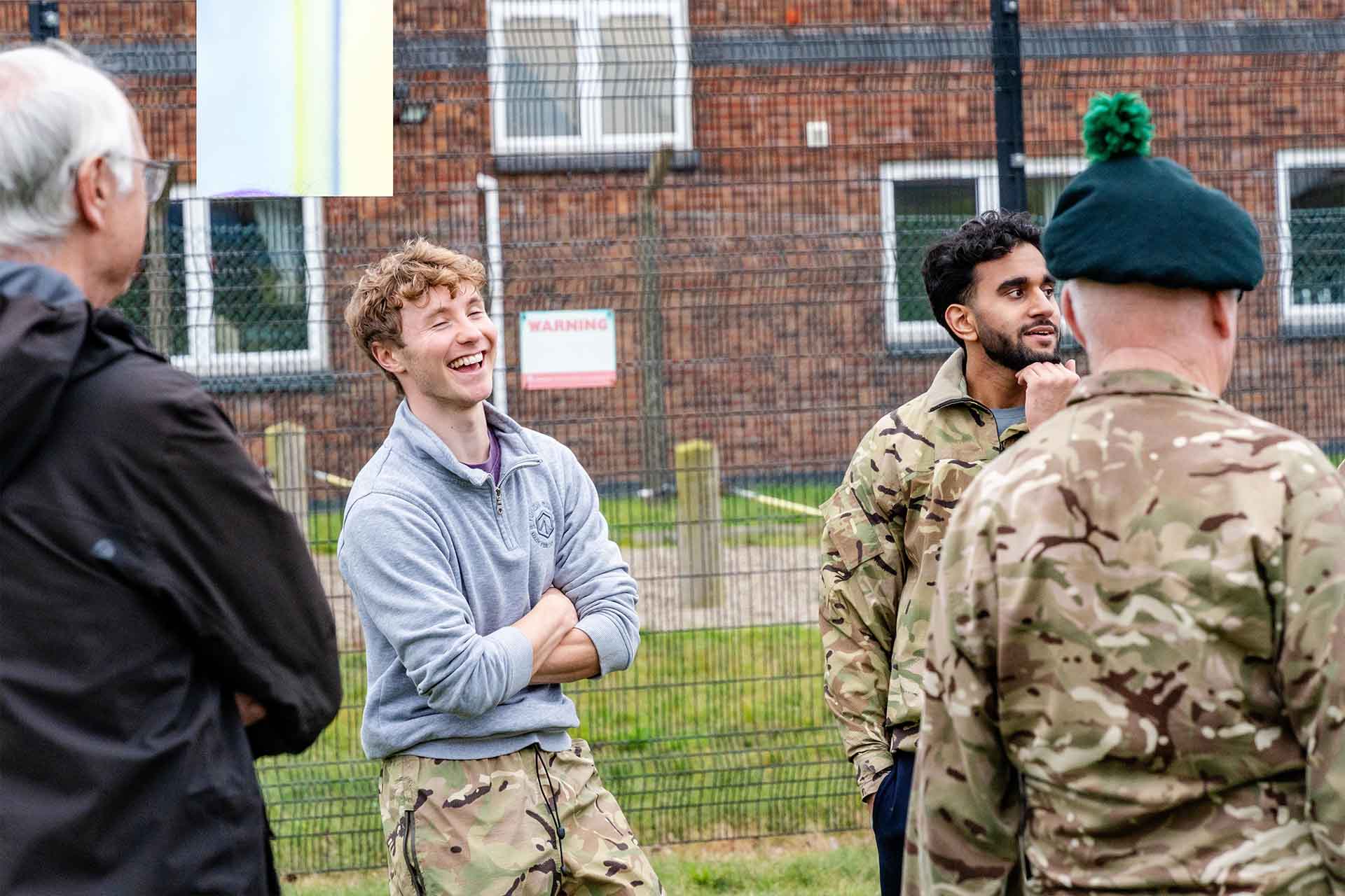 A young male student laughing in amongst a group of colleagues