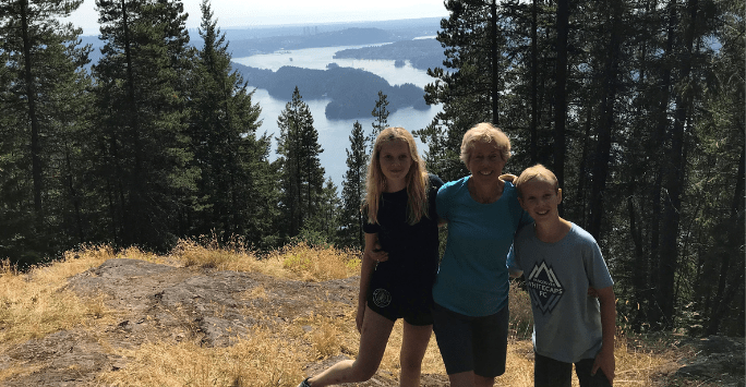 woman on a hike in the mountains with two grandchildren