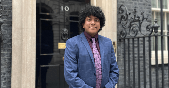 man in formal suit poses outside of 10 Downing Street