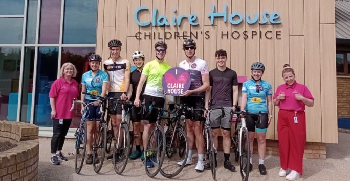 Student cyclists pose with their bikes outside Claire House