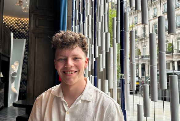 Jonathan Oliveira sits in front of a window and smiles