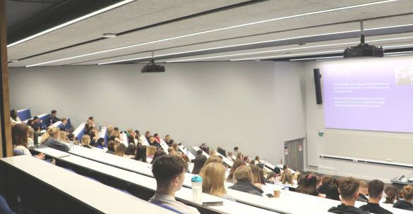 Students sit in rows in a lecture theatre