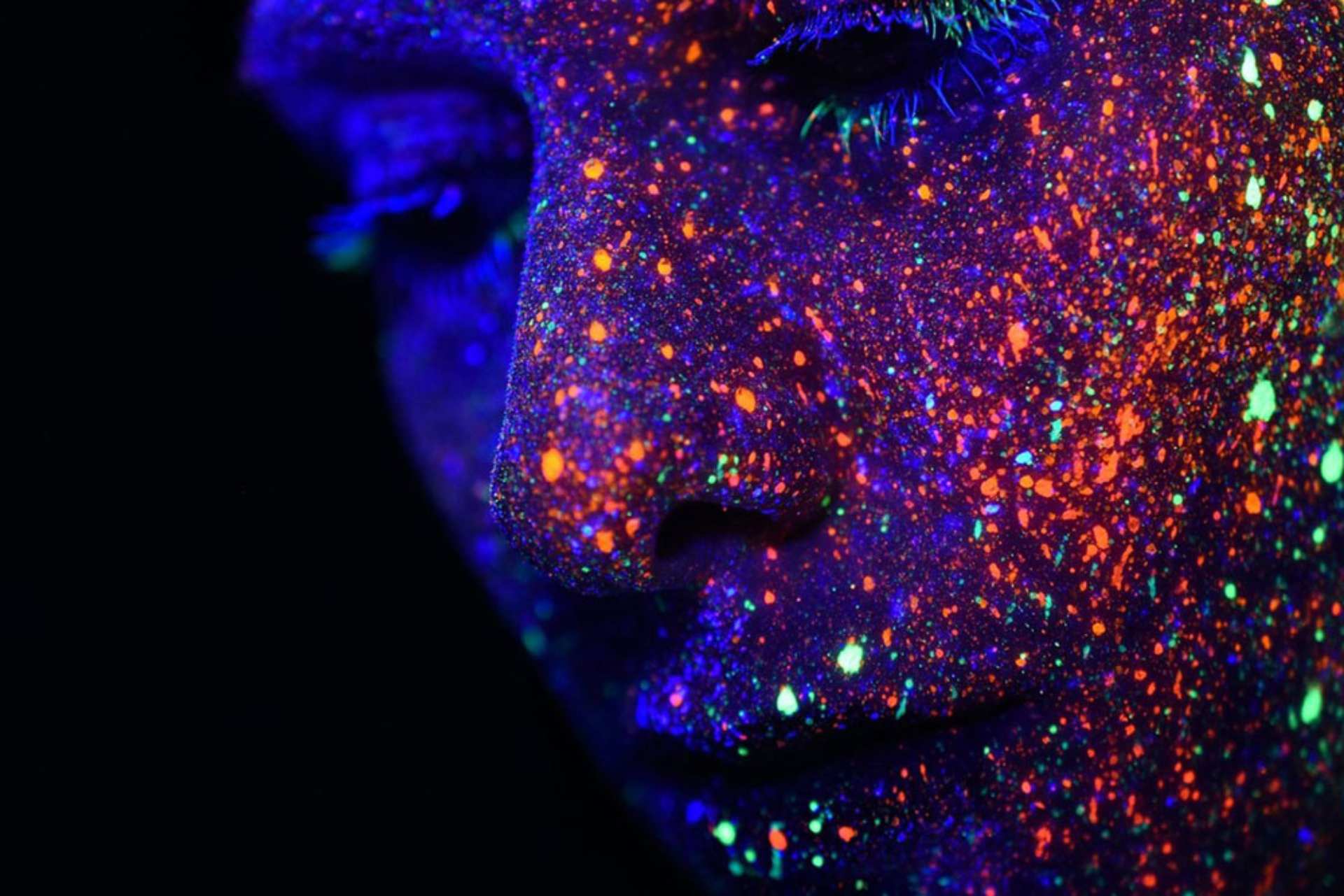 Close up of face lit up with multi-colour lights