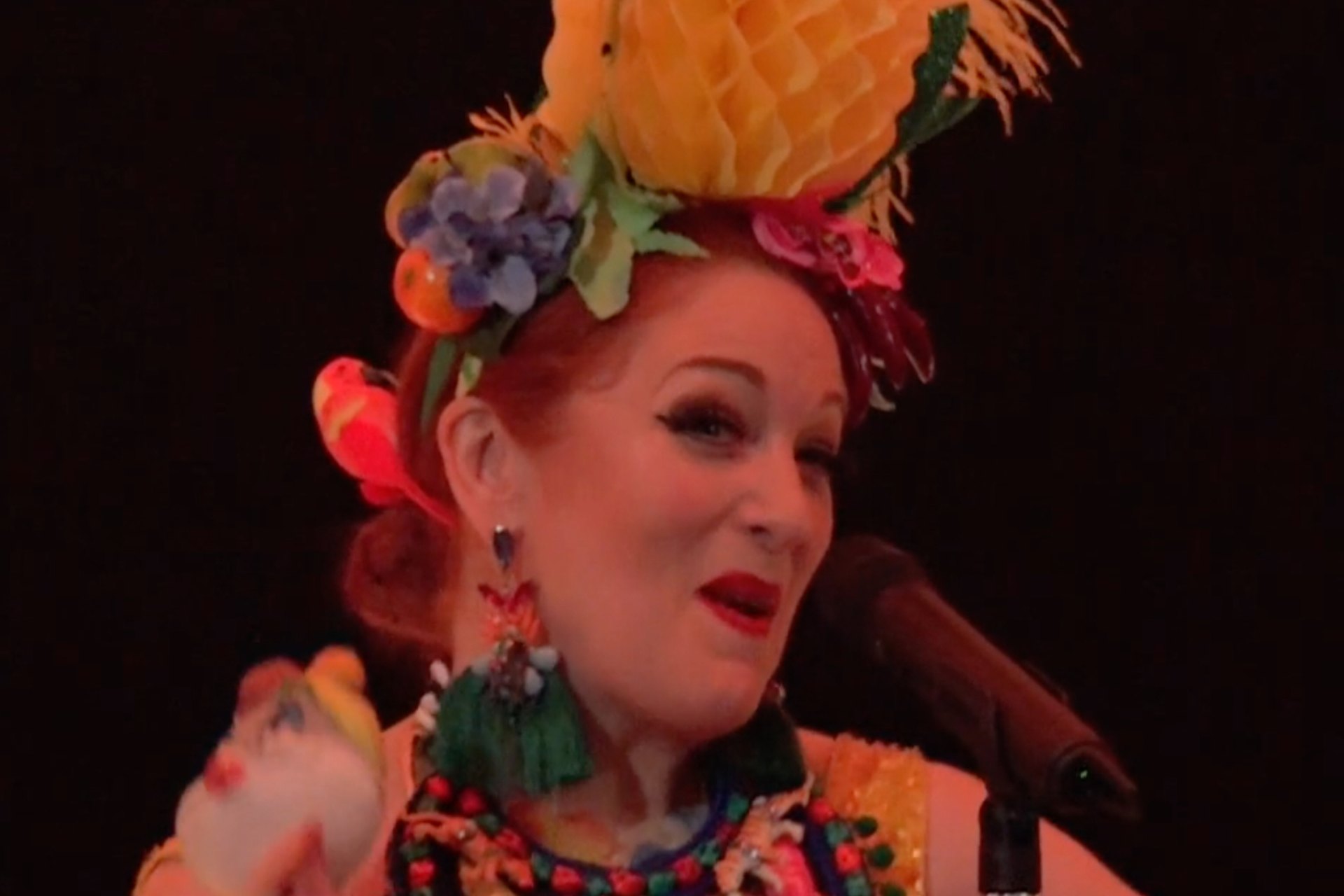 Close up photo of performer with colourful headress