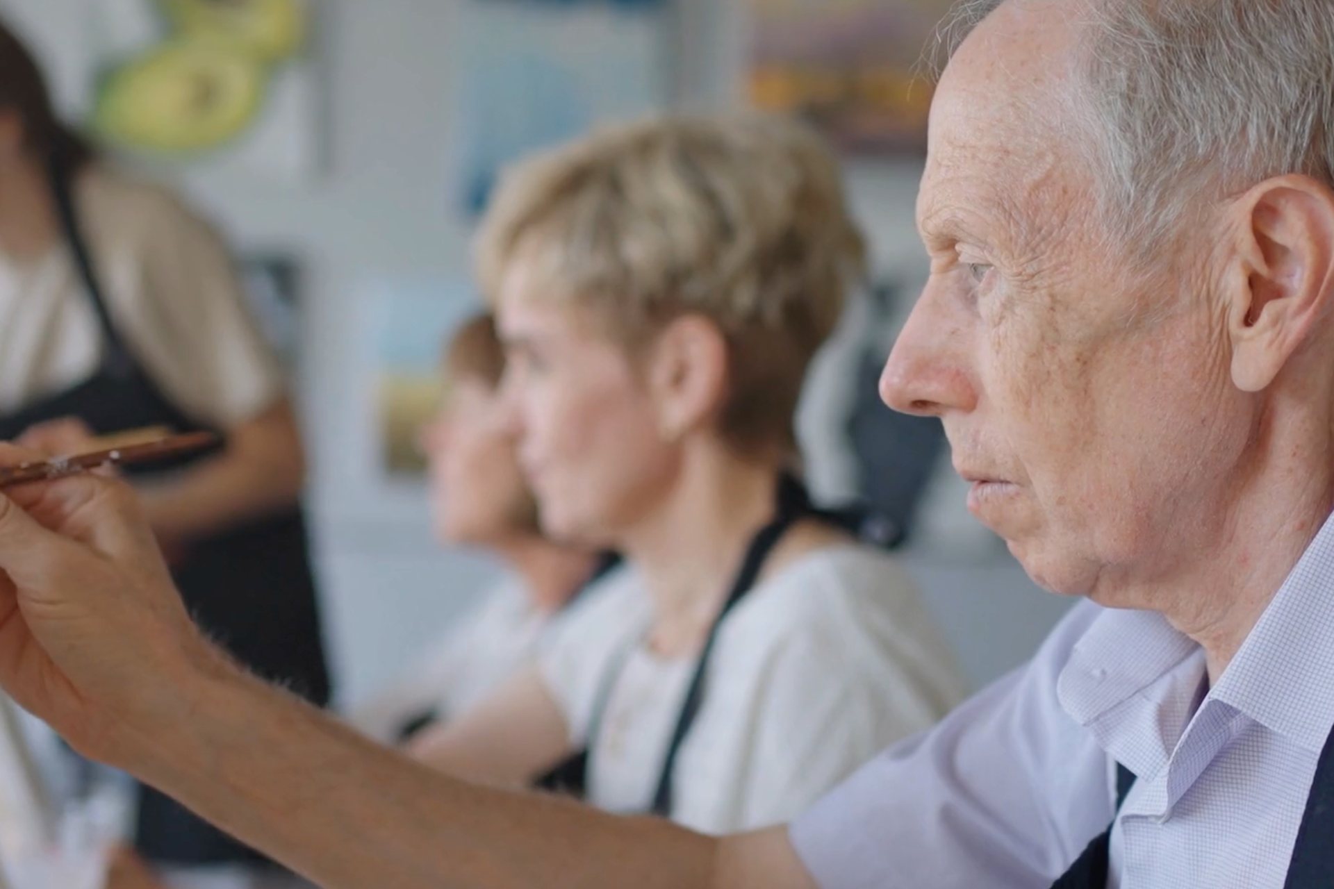 Photo of older adults painting in a classroom