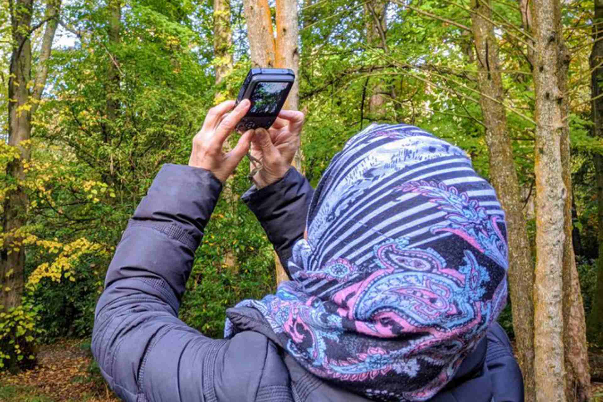 Woman taking photo in the woods