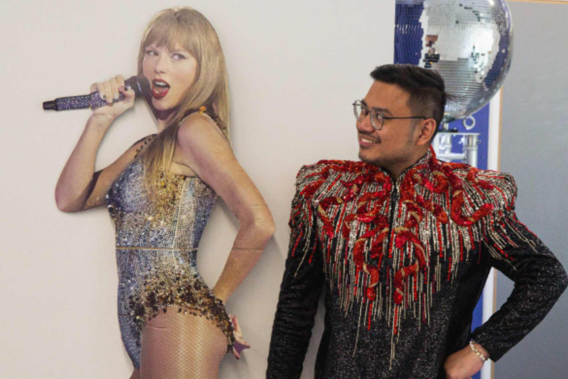 Fan standing next to cardboard cutout of Taylor Swift