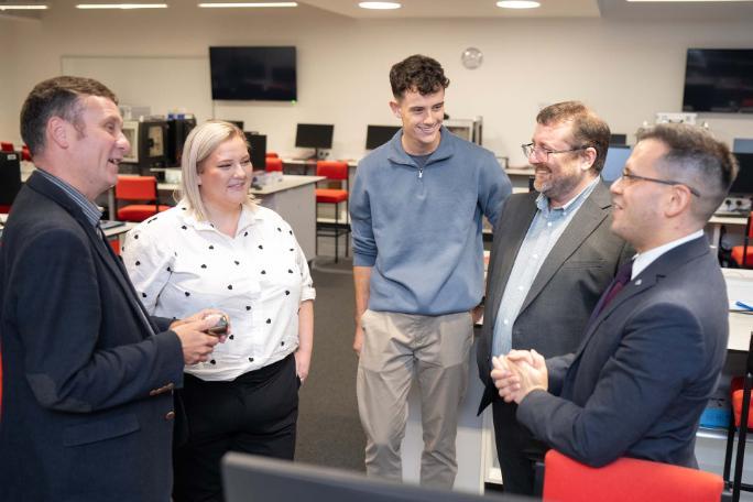 Ioan Hughes standing and chatting with Professor Andy Boston, Professor Dave Joss, fellow PhD Nerys Davies, and Pete from Sizewell C