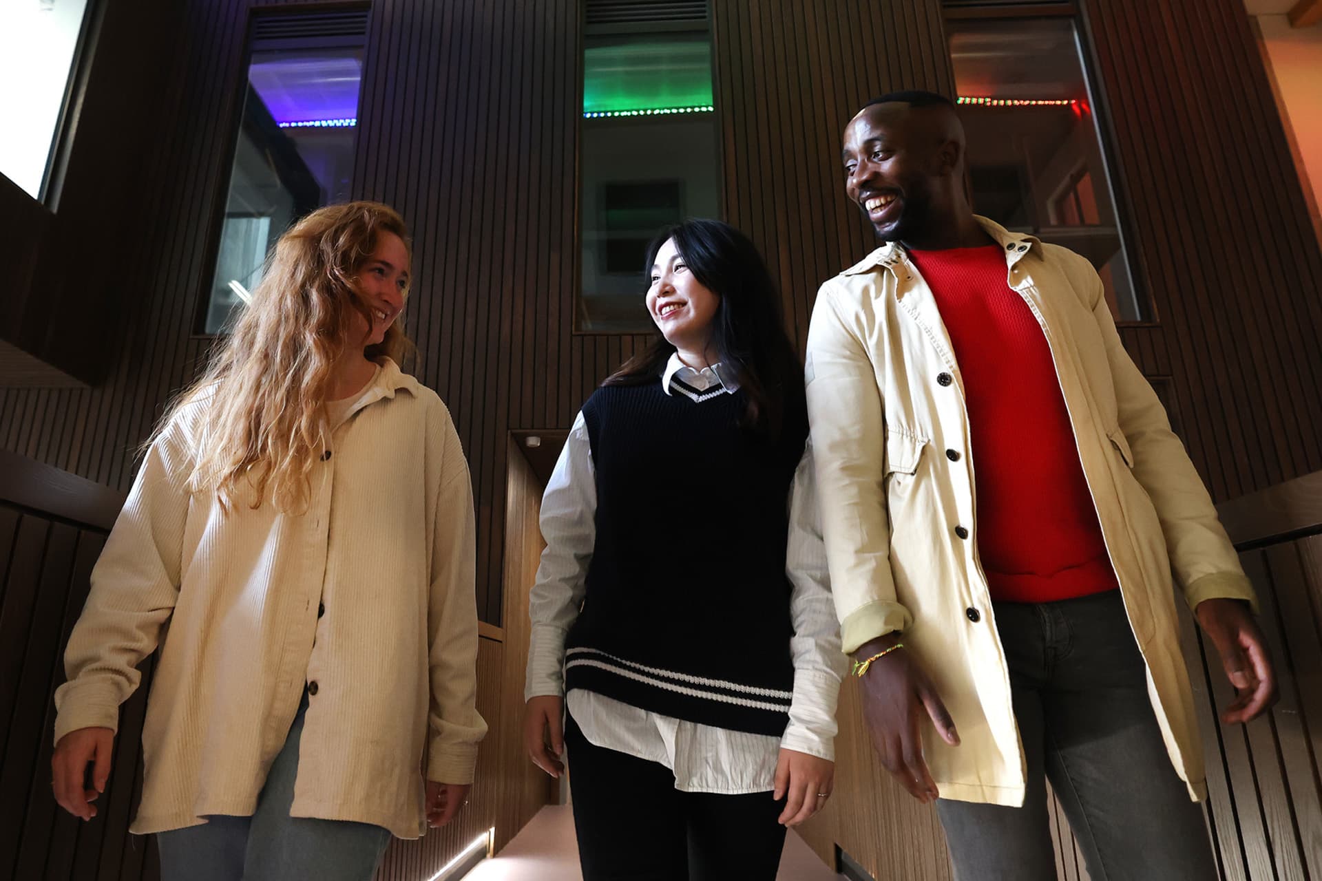 Three students walk together inside the School of Law and Social Justice building.