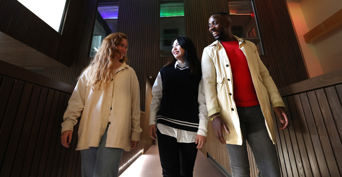 Three students walking through the School of Law and Social Justice building.