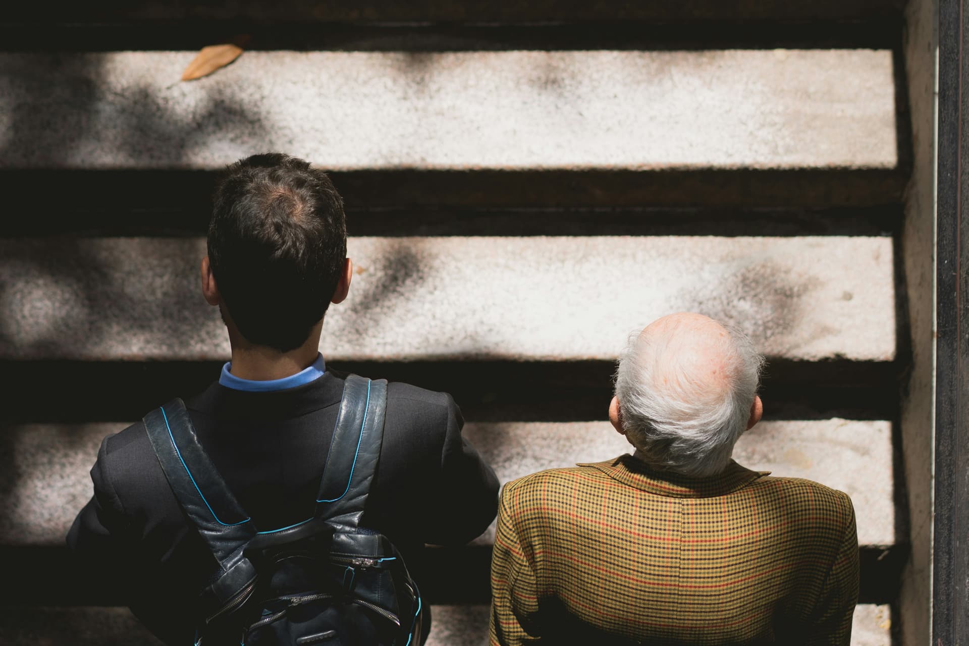 Older man and younger man walking up stairs.