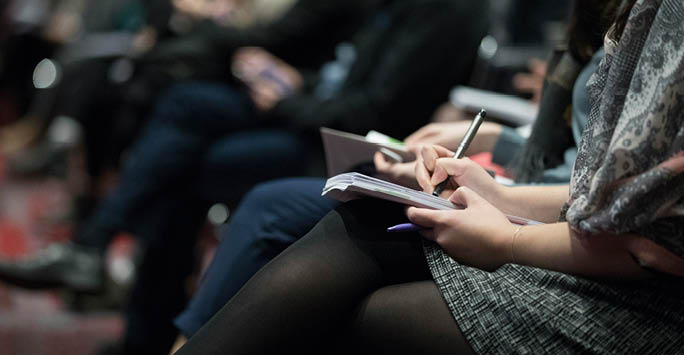 A girl taking notes at an event.