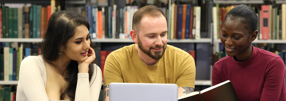 Three students sit together studying.