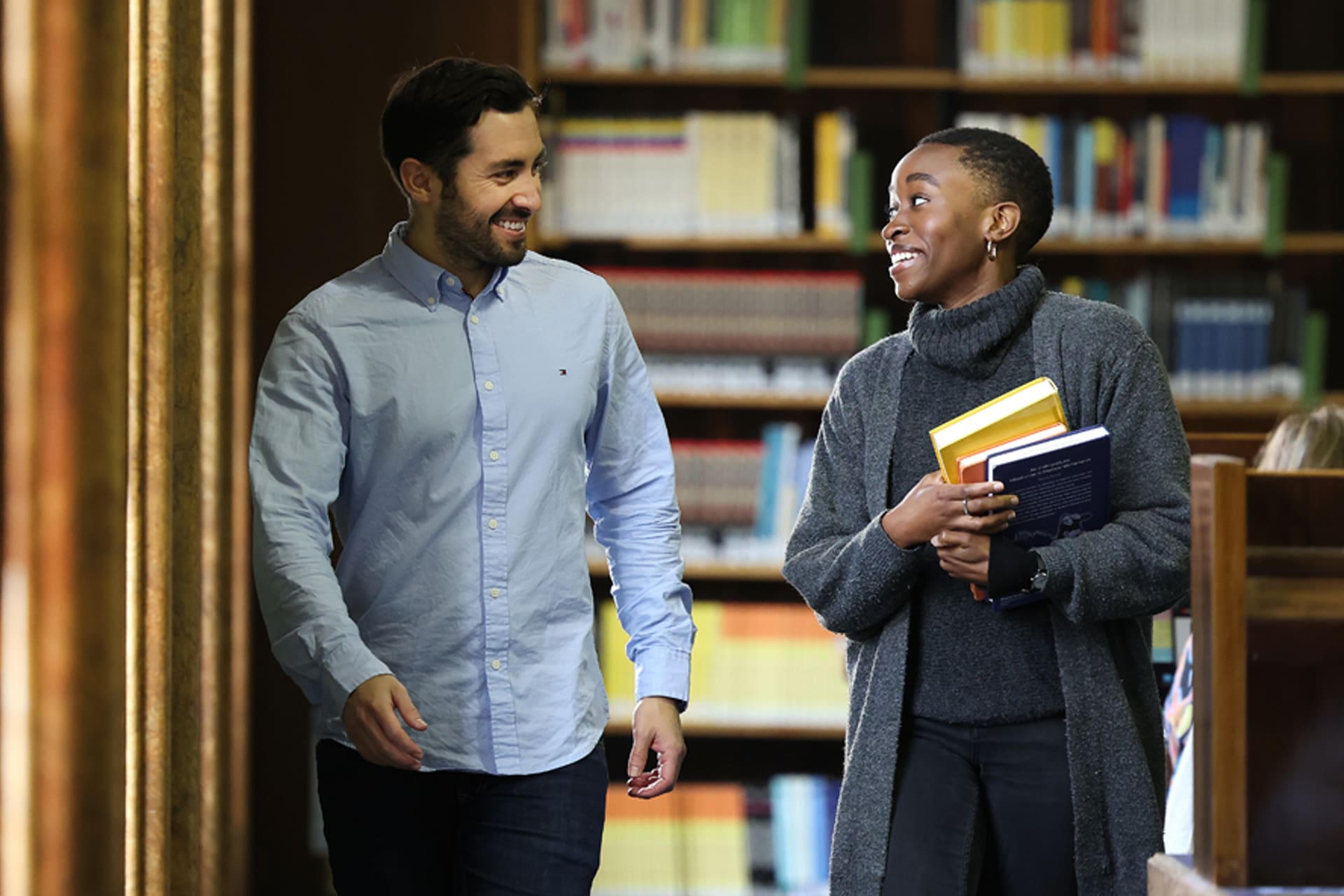 Two student walking through the library together.