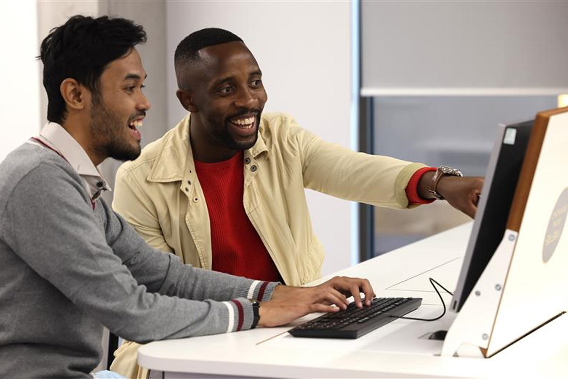 Two international students using a laptop