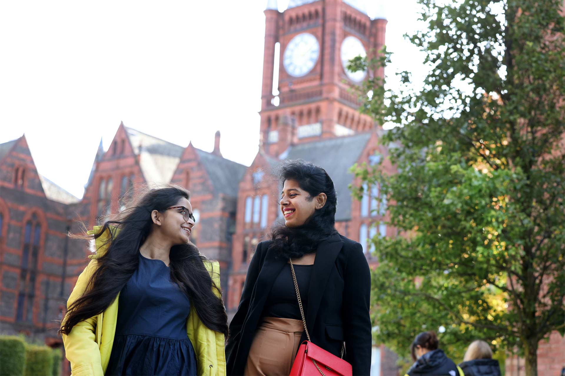 Two international students walking across campus