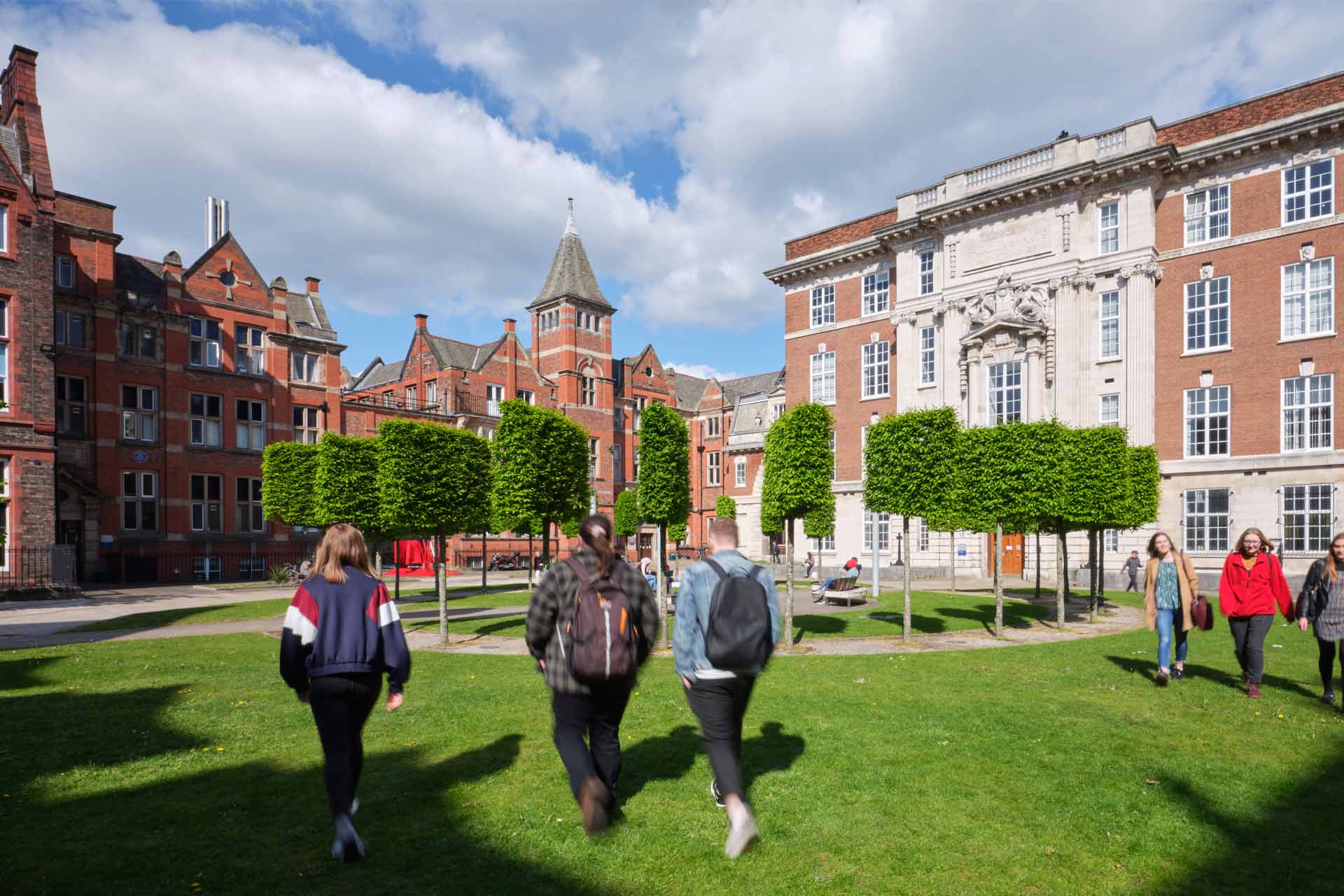 Threes students walking through The Quadrangle