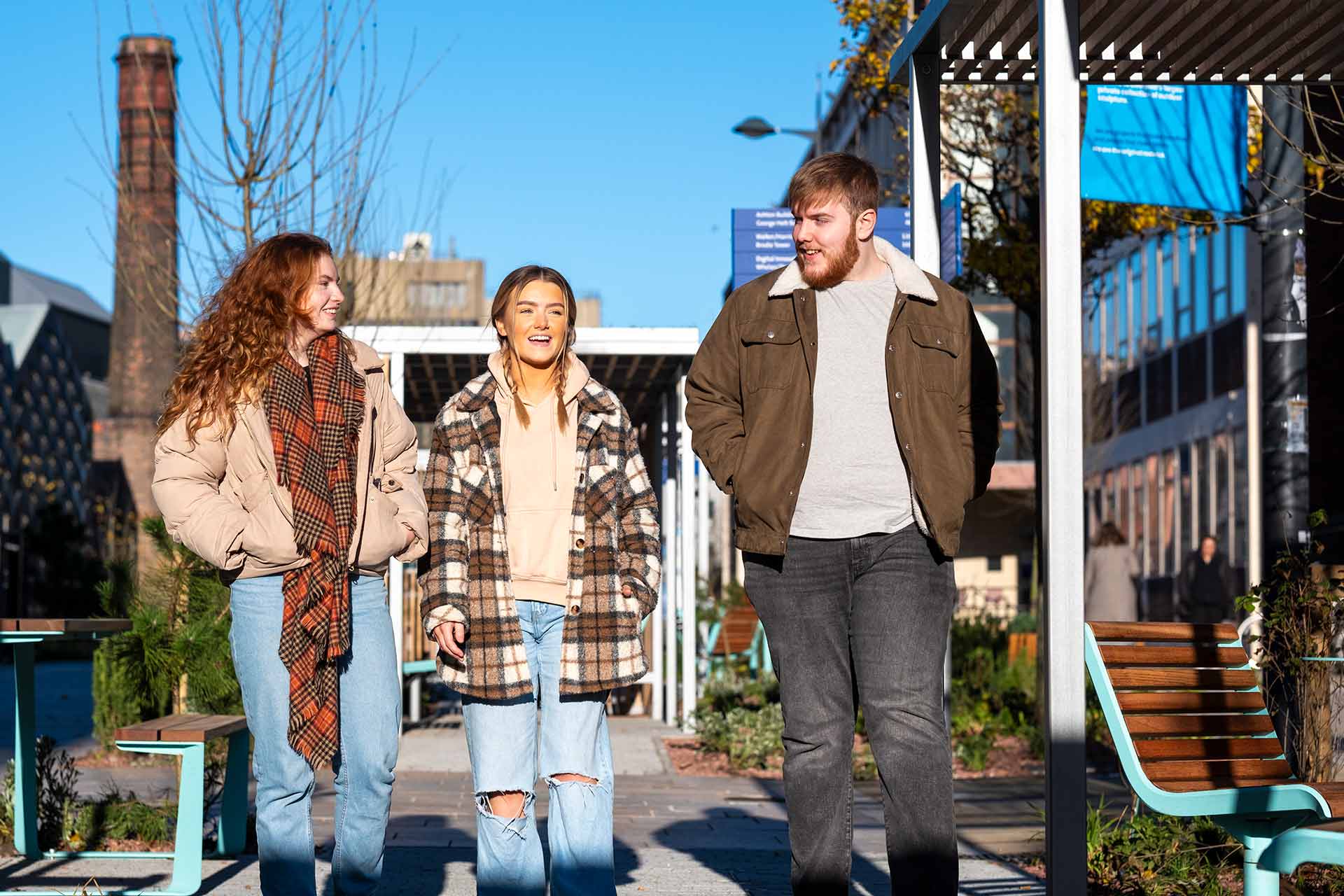 Three students walking on campus.