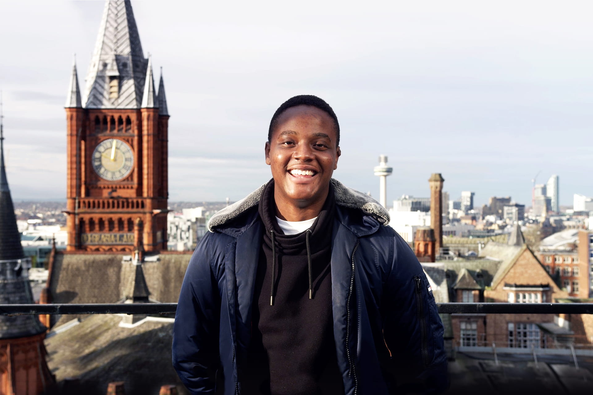 A student smiling with the Victoria Gallery and Museum in the background.