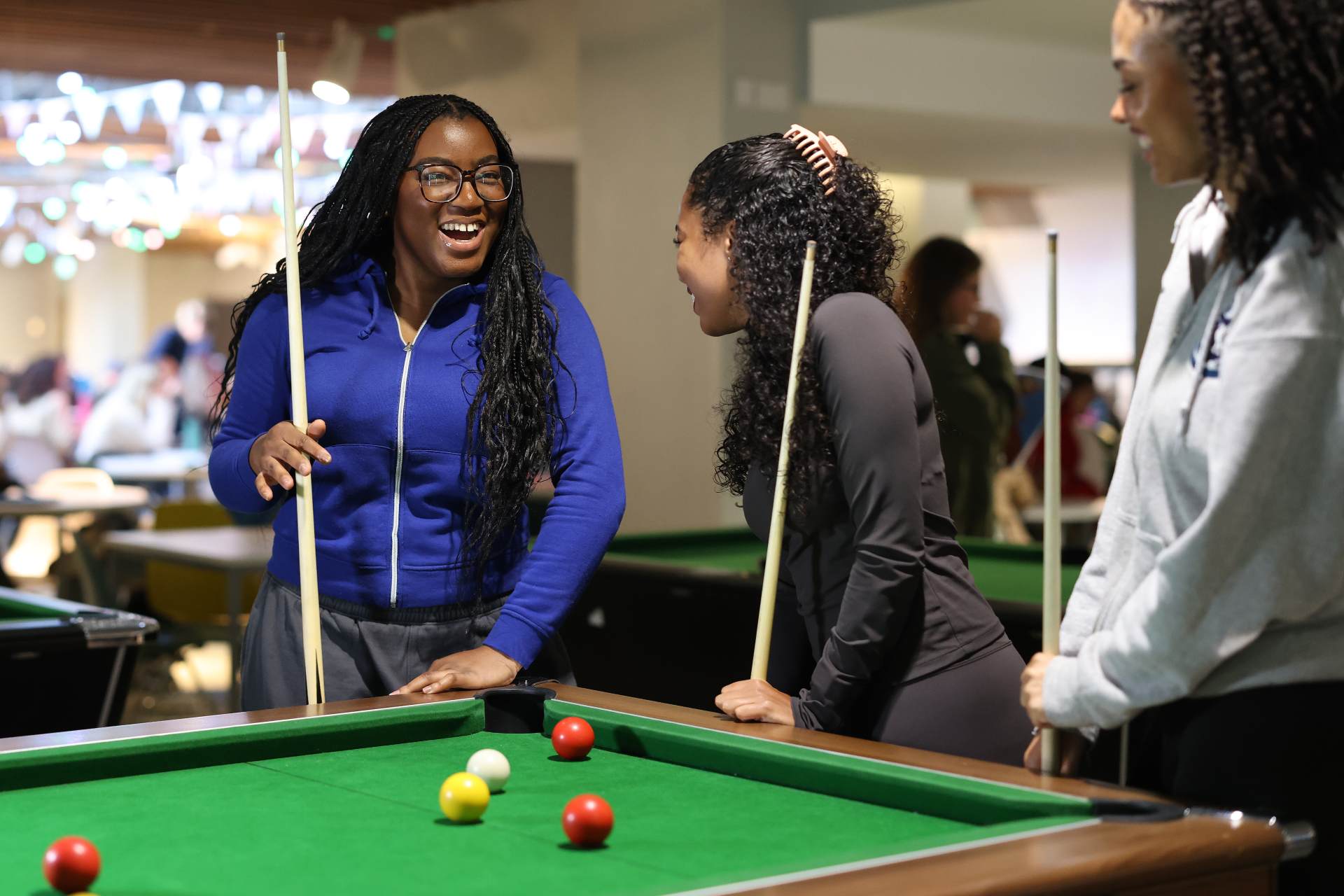 Three students playing pool.