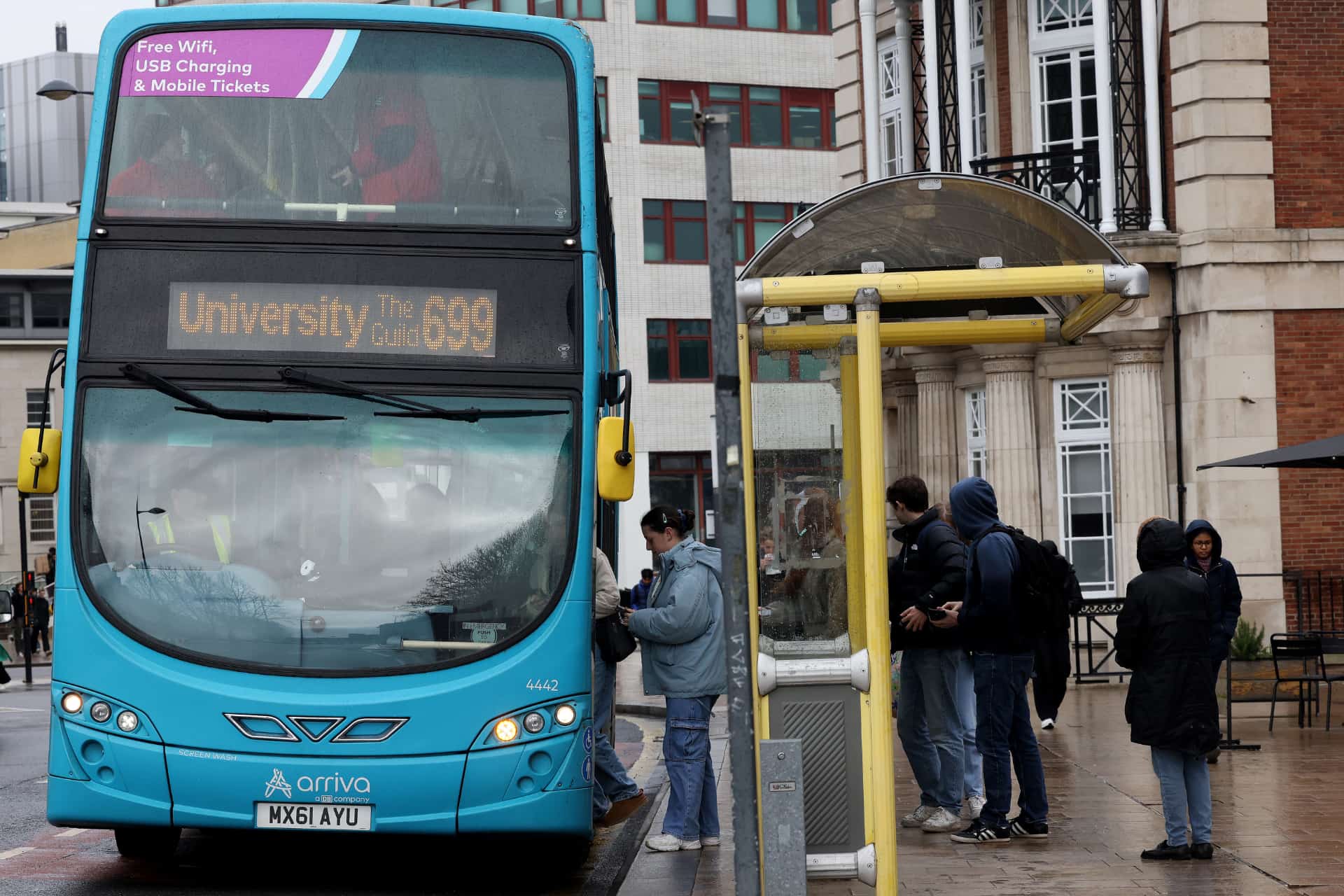 The 699 bus on the University Campus stopped with people getting on.