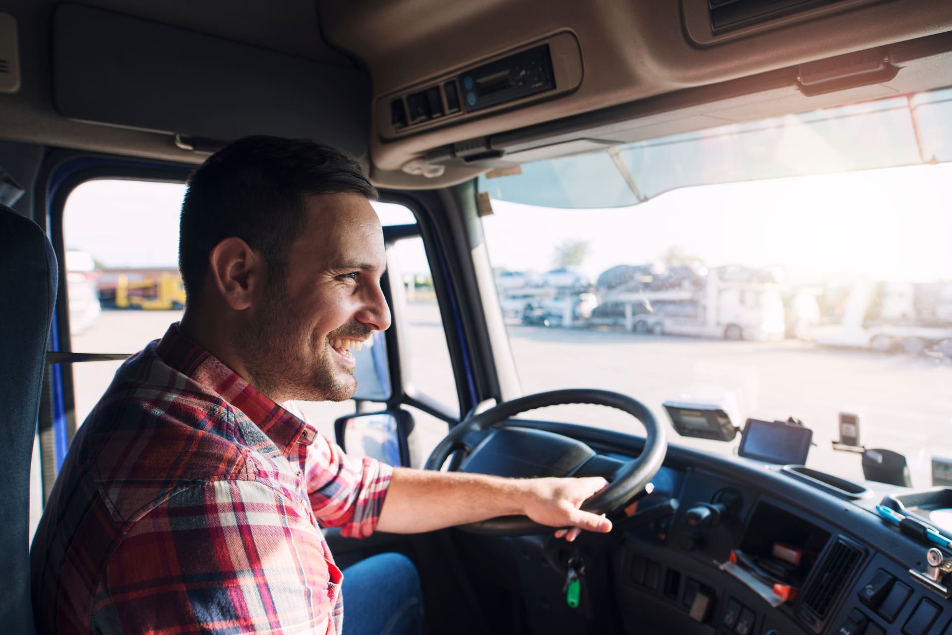A man smiling and driving a truck.