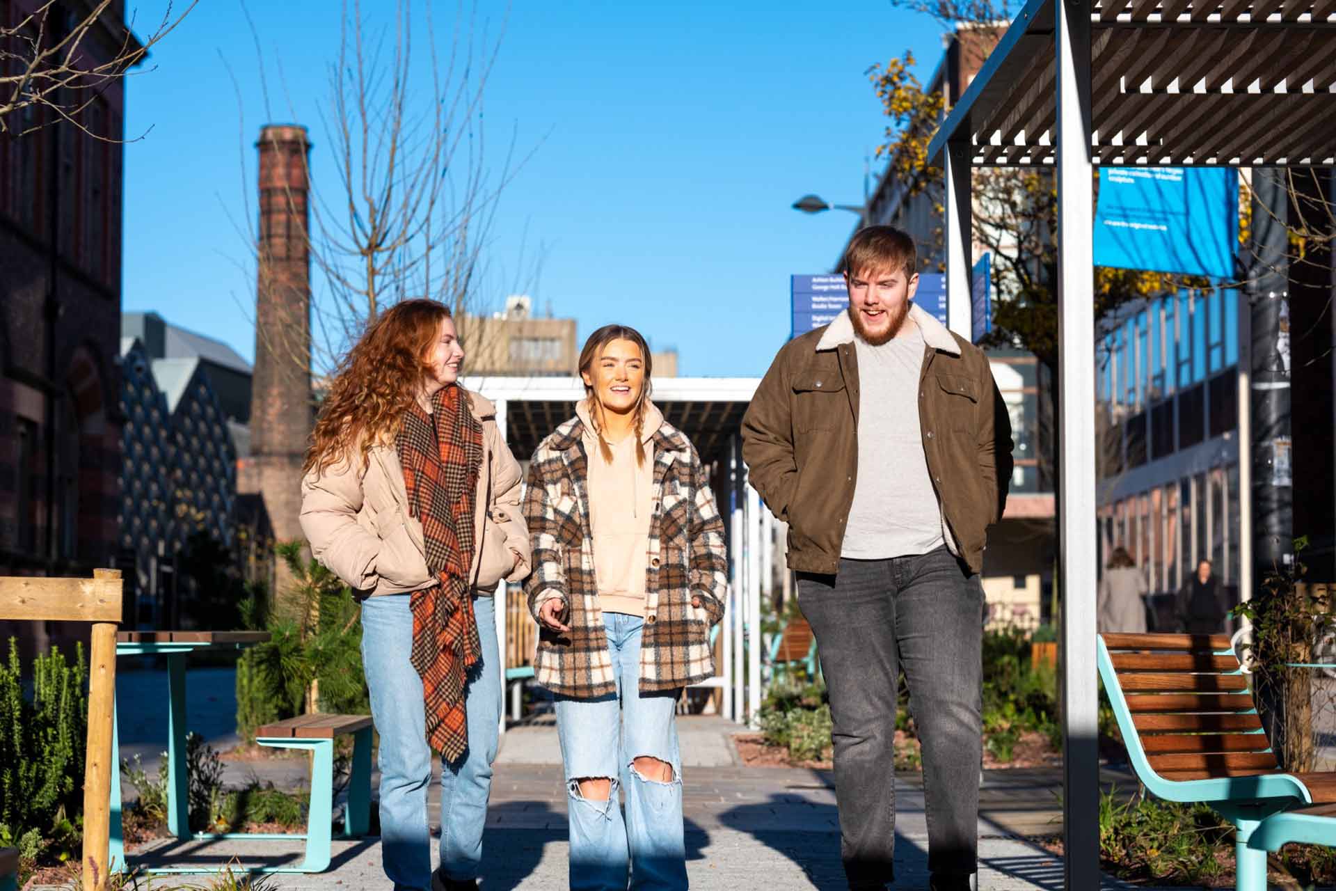 Three students walking on campus