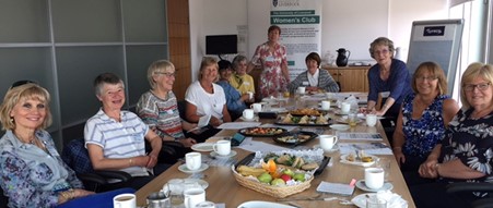 Women's Club members sitting around a table